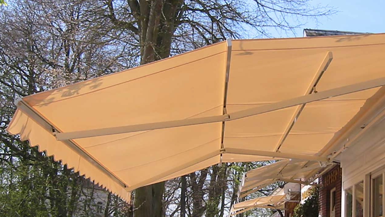 Grüne Terrassenmarkise für stilvollen Sonnenschutz Orange Markise über einer Terrasse eines Restaurants